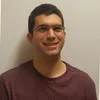 Jose M Tipton in glasses and a maroon tee, photographed against a plain wall