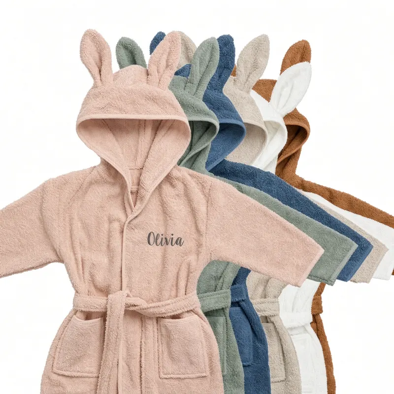 Bunny-ear hooded baby robes in a run of colours, the front one embroidered with a name