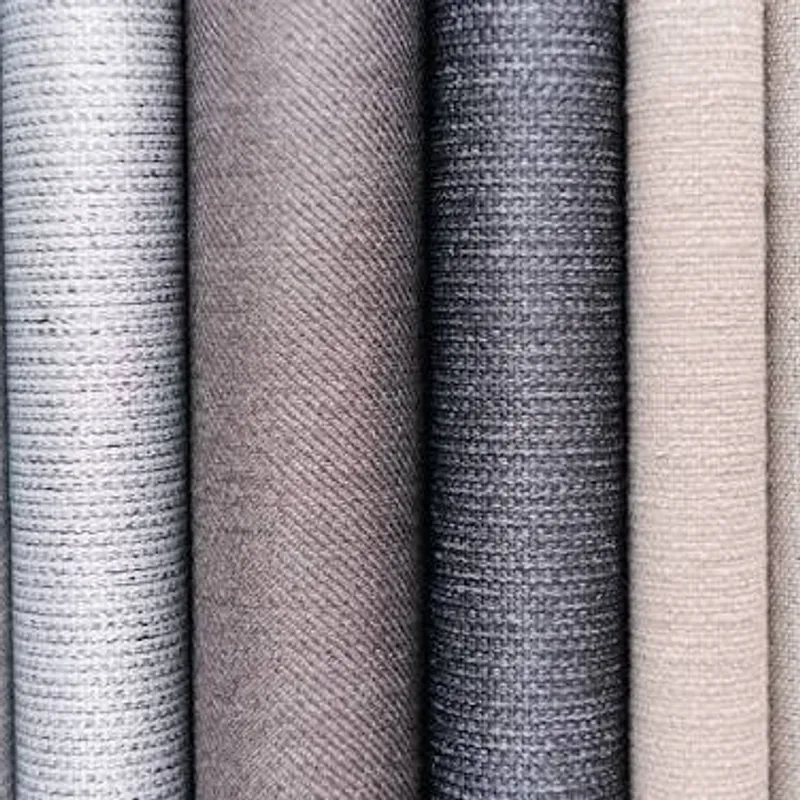 Rolls of matte woven cloth side by side, white through taupe to charcoal