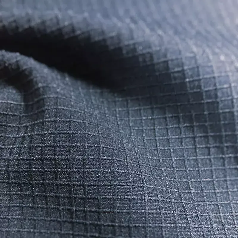 Dark navy cloth with a visible grid weave running across a soft fold