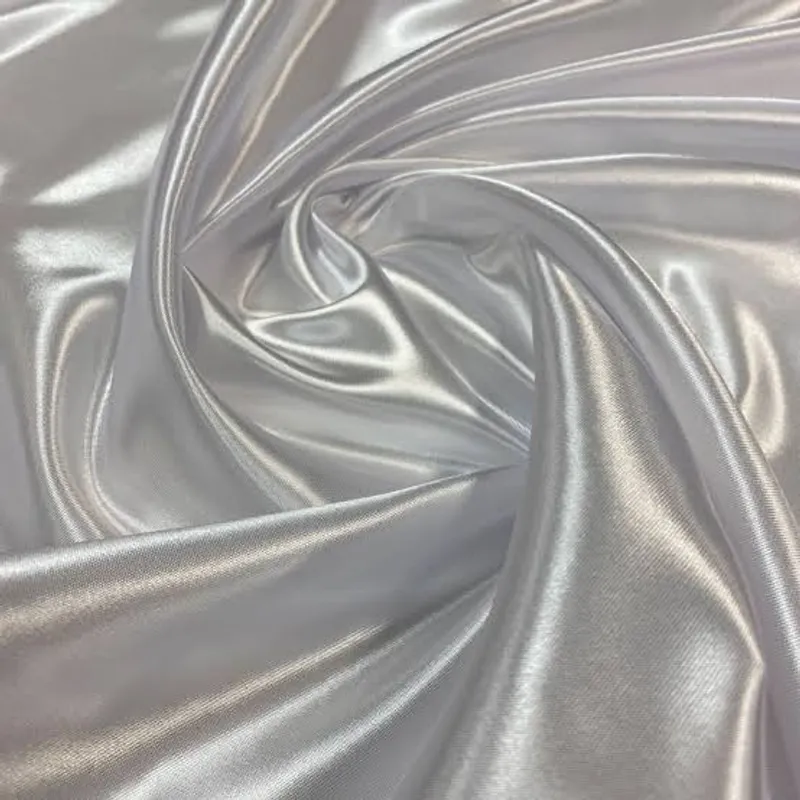 Pale silver cloth gathered into liquid, high-sheen folds at the centre