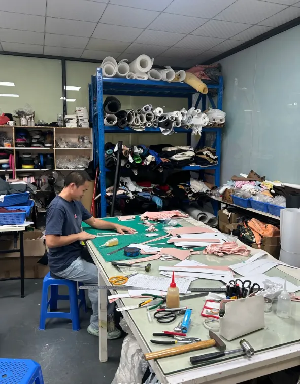 A pattern-maker at a cutting table in the JaceApparel workshop — cut-and-sew, print and labelling in one production system