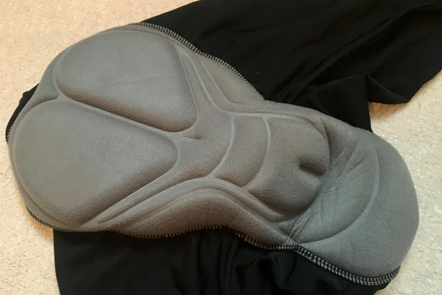 Multi-panel grey chamois pad sitting inside a black bib short, its contouring raised above the fabric