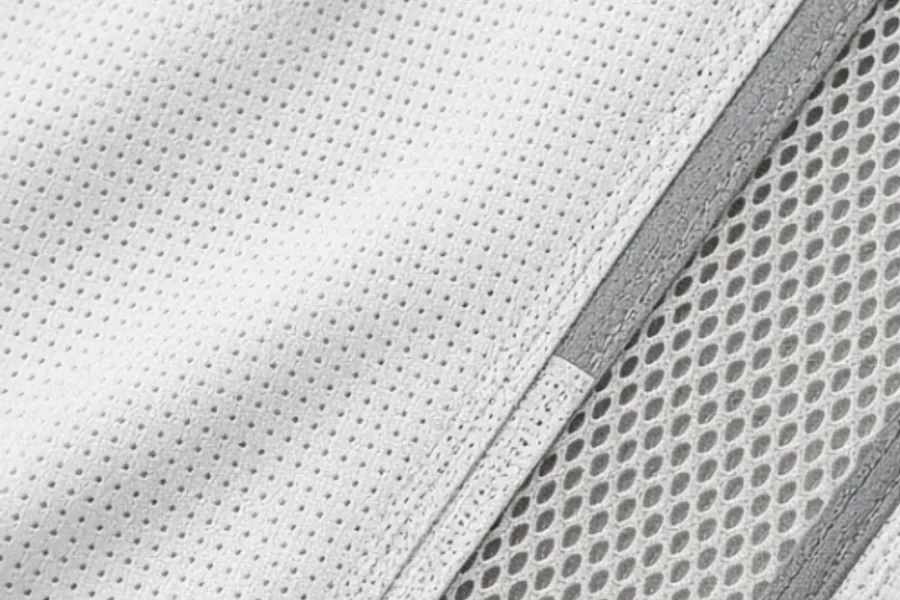 Perforated white knit filling the frame, a band of open mesh running diagonally below it