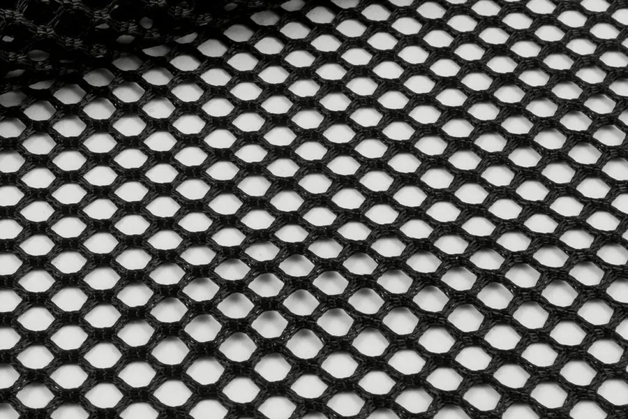 Diamond open mesh filling the frame in black, one corner folded back on itself