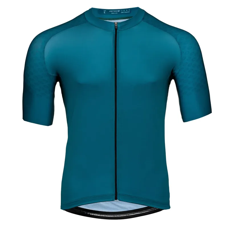 Teal short-sleeve jersey laid flat on white, a full-length zip down the front and dotted fabric across the raglan sleeves