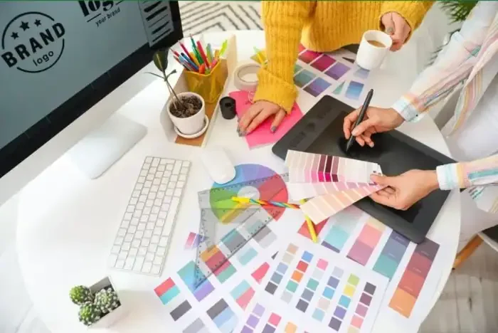 Swatch fans, a stylus and a monitor on the desk where a logo is digitised
