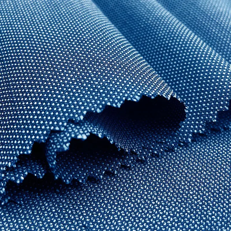 Ragged edge of a navy pointelle mesh lit from behind, the open structure reading as a field of pale dots