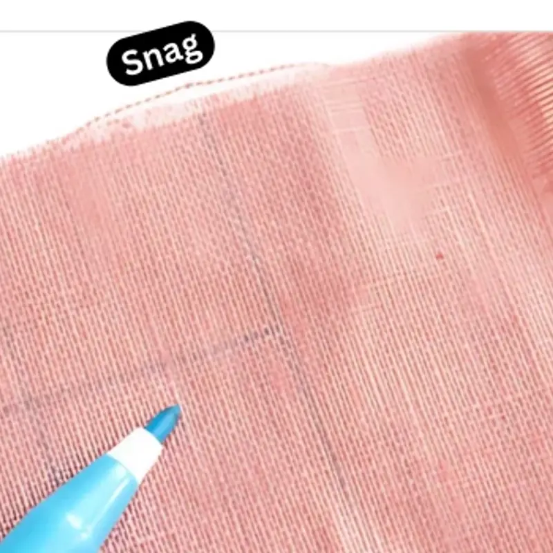 Pink grid-woven cloth with the tip of a pen drawn across it, a black label reading Snag above
