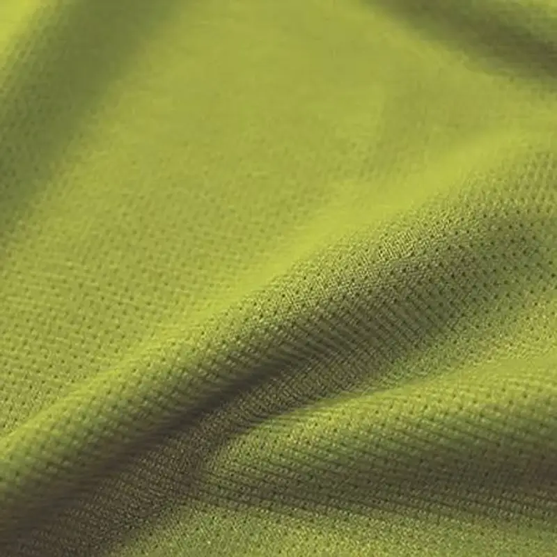 Folded lime-green mesh knit photographed close, its open structure reading across the frame