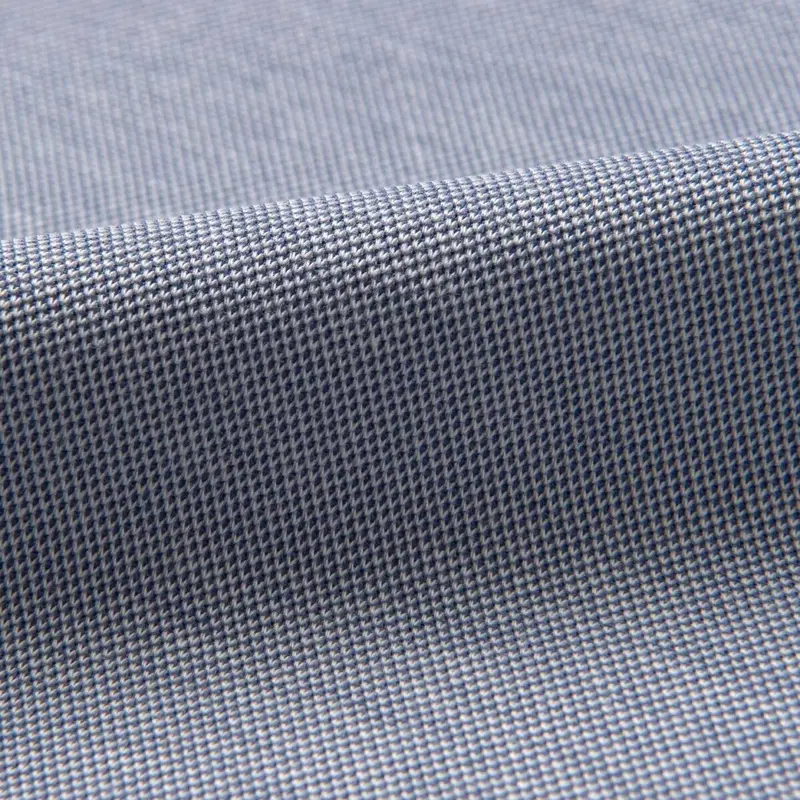 Pique knit macro in blue-grey filling the frame, an even grid of raised squares running diagonally under a soft ridge