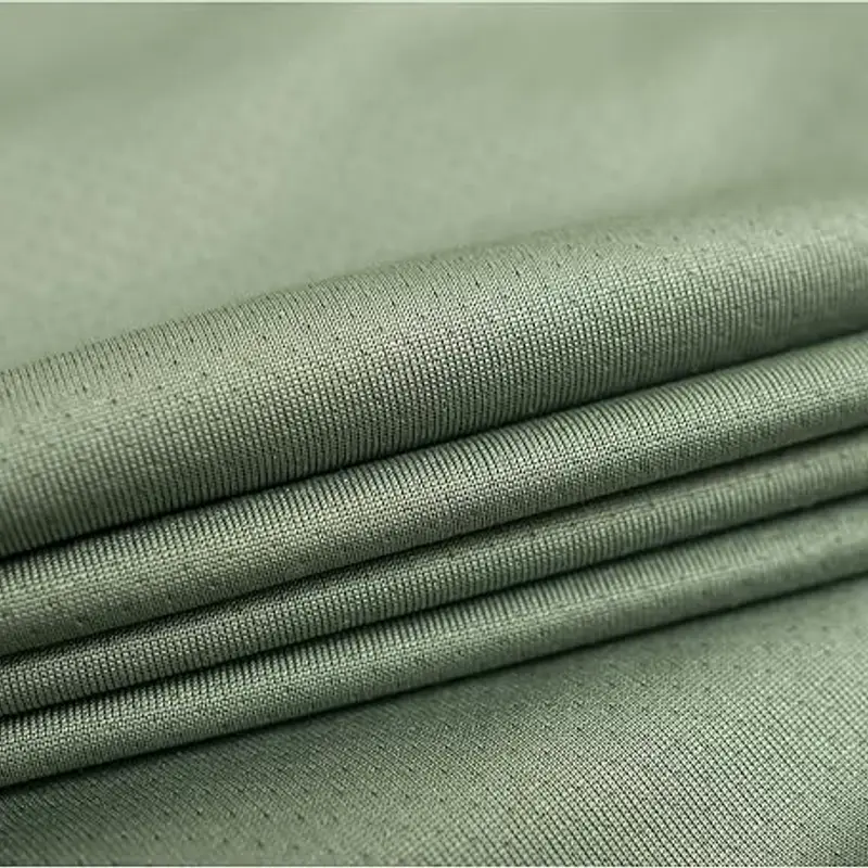 Sun-blocking knit in pale sage green folded in four even layers, its fine weave catching the light