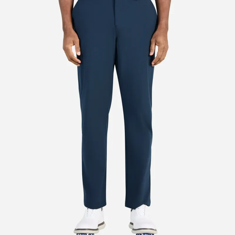 Full-length navy trousers worn with a white belt and white spiked golf shoes, shot from the waist down