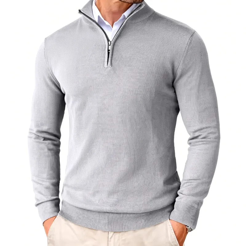 Quarter-zip knit in light grey worn over an open shirt collar, hands resting in the pockets of beige trousers