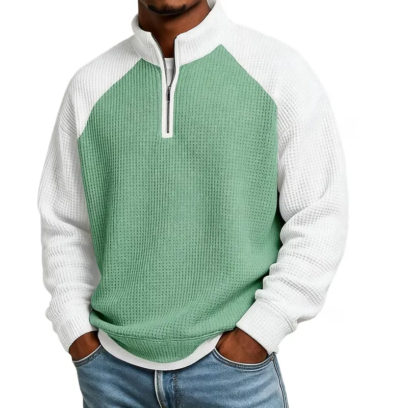 Raglan seams running from the underarm to a stand collar on a green and white quarter-zip