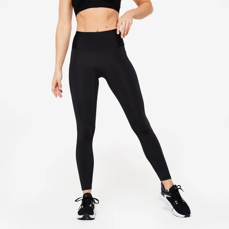 Stepped shot of high-waist leggings worn with a matching crop top, shot against a plain studio wall