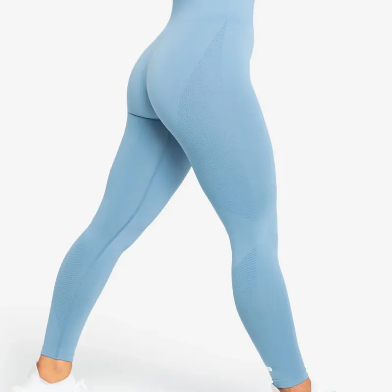 Seen from behind mid-stride in pale blue seamless leggings, the knitted zones reading as texture rather than a seam
