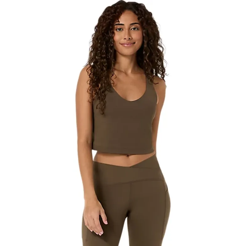Modelled in a brown scoop-neck crop top with matching leggings, shown front on against white