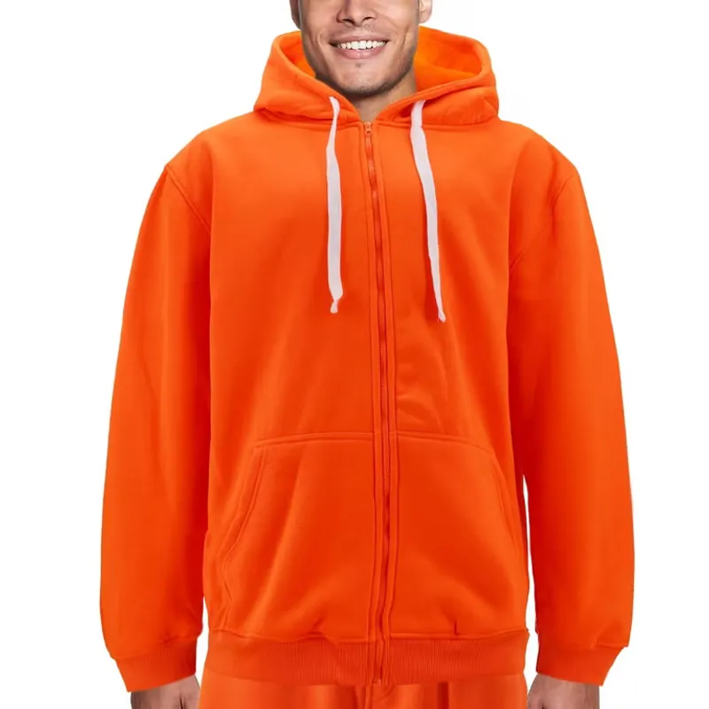 Zipped up in a bright orange hoodie with white drawcords, a kangaroo pocket and ribbed cuffs