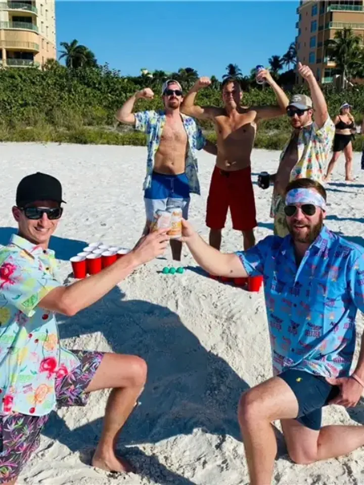 A group on the beach in matching bright-blue Hawaiian shirts