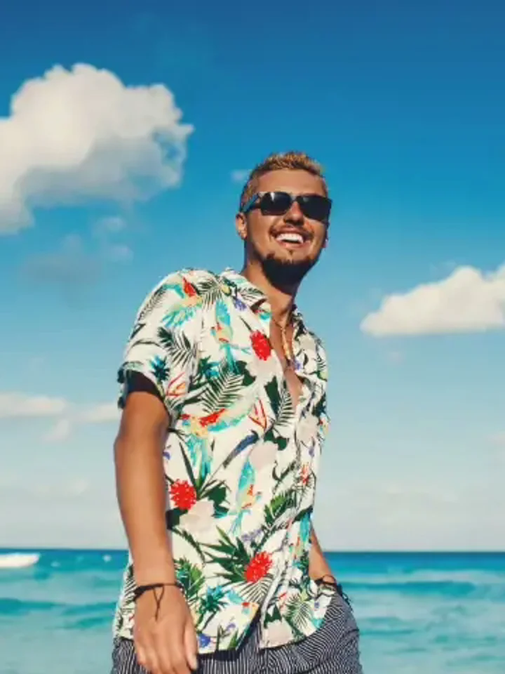 A customer in a white floral Hawaiian shirt by the ocean