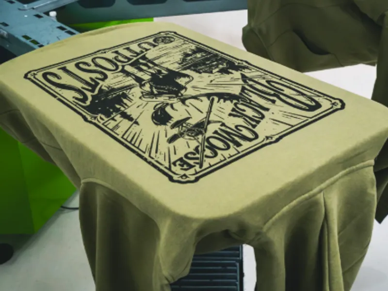Screen-printing press laying ink onto a hoodie