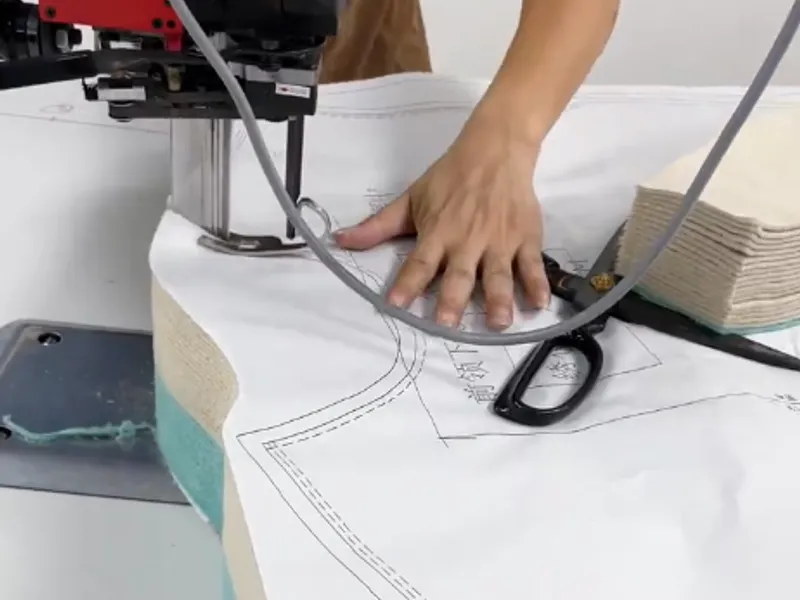 A tailor trimming a hoodie by hand