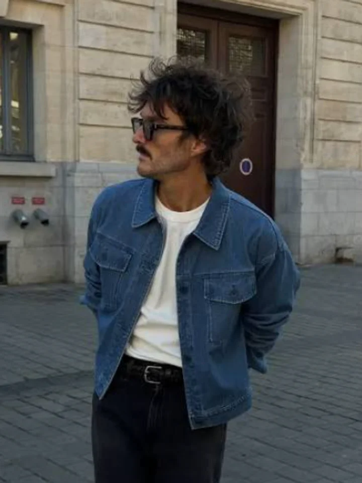 Light-wash denim jacket and glasses on a cobbled street