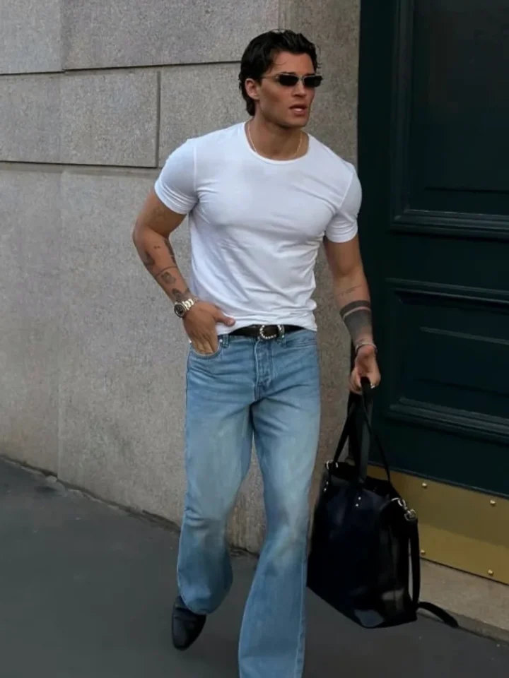 A customer in light-blue flared jeans and a white tee walking down the street