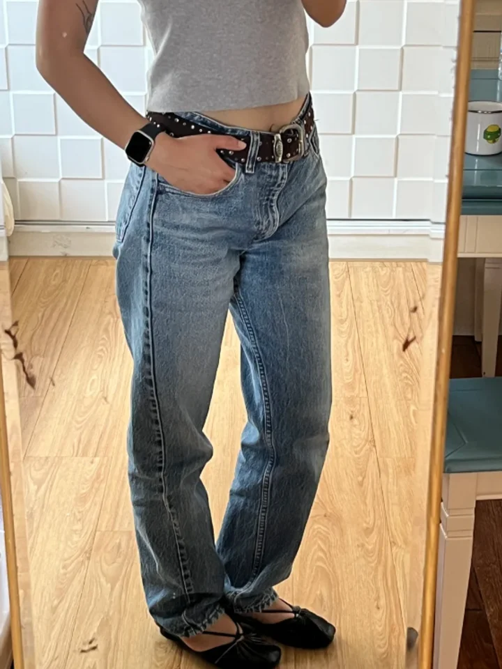 A customer in blue low-rise jeans and a studded belt