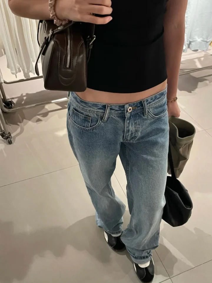 A customer in blue baggy jeans with a brown crossbody bag