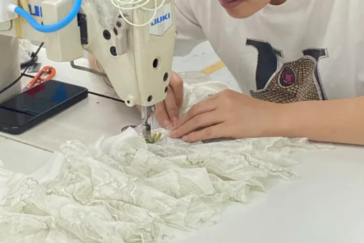 Lace panels fed through a sewing machine, sewn into a run