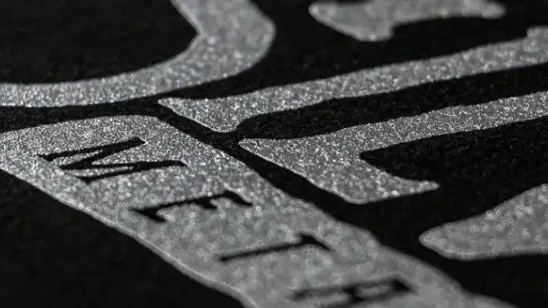 Close-up of a silver metallic ink print across a dark garment