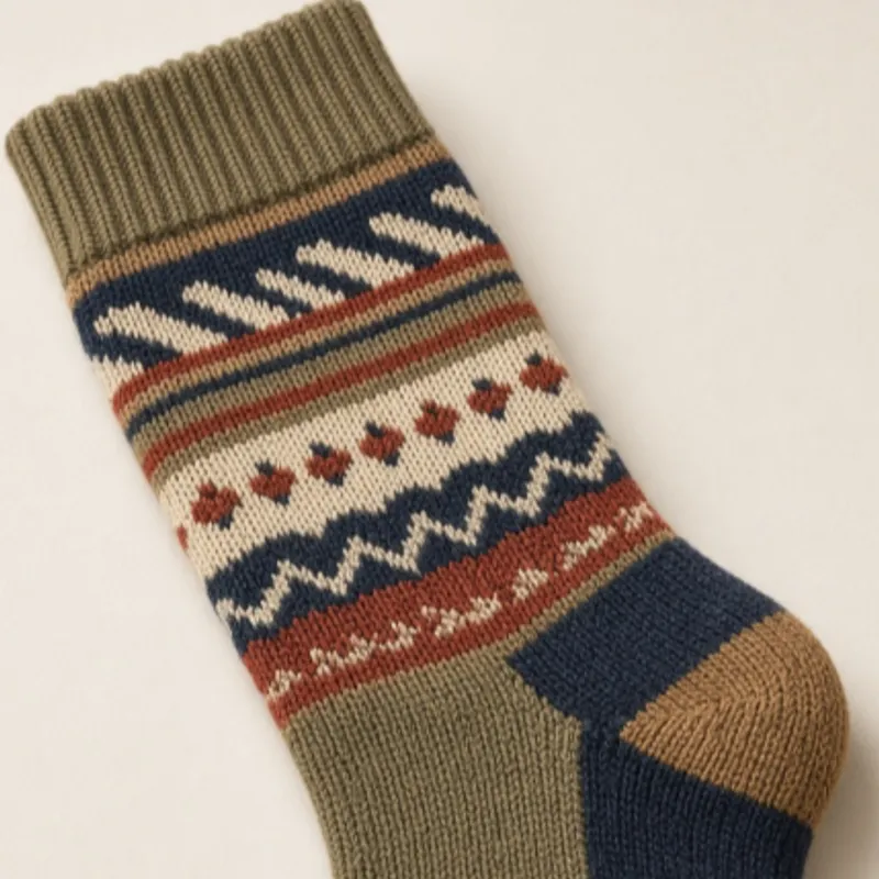 Zigzag fair-isle bands knitted across a sock in olive, navy and rust