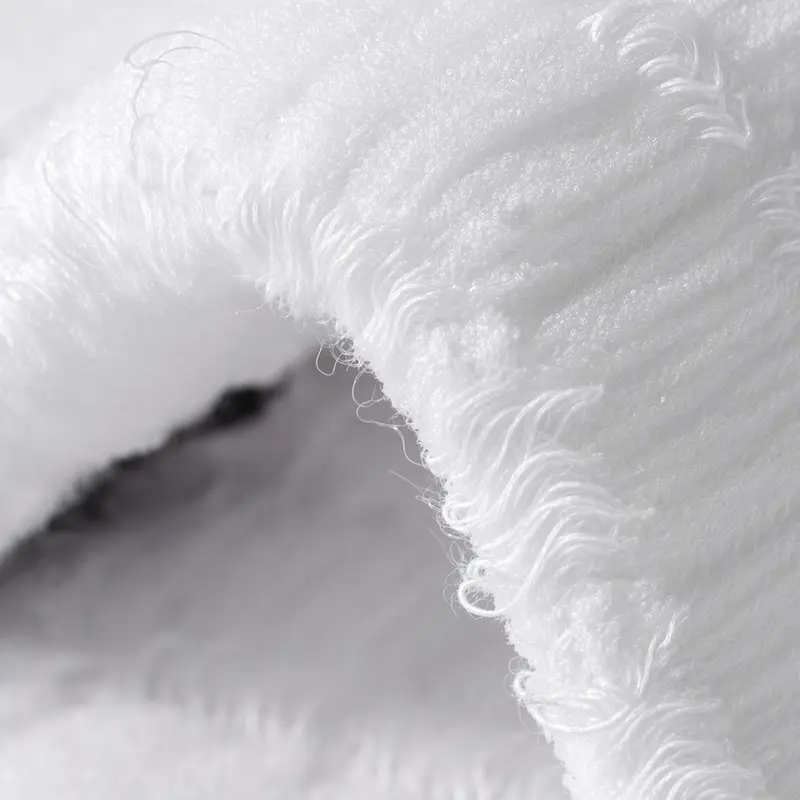 Fluffy white cotton fibre photographed close, its surface raised into soft loops