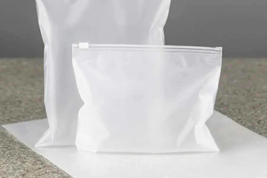 Frosted zip bags standing empty on a pale sheet, a large one behind a smaller