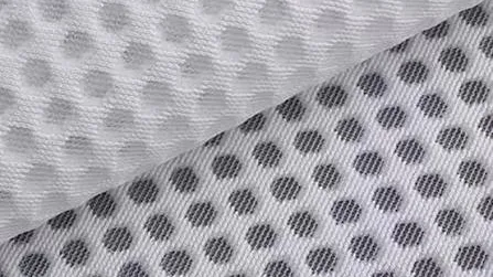 Close-up of a white breathable mesh panel with an open honeycomb structure