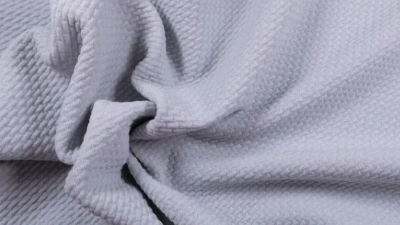 Close-up of a pale lilac four-way-stretch knit with a ribbed surface