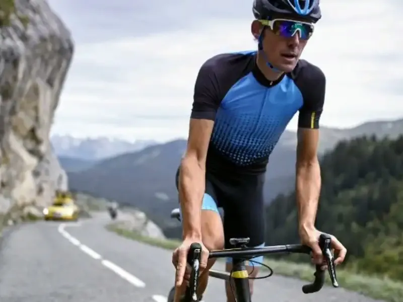 Cyclist in a printed jersey and padded bib shorts riding a mountain road