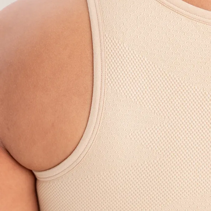 Close on the shoulder of a seamless compression top, the fine mesh knit running over the arm