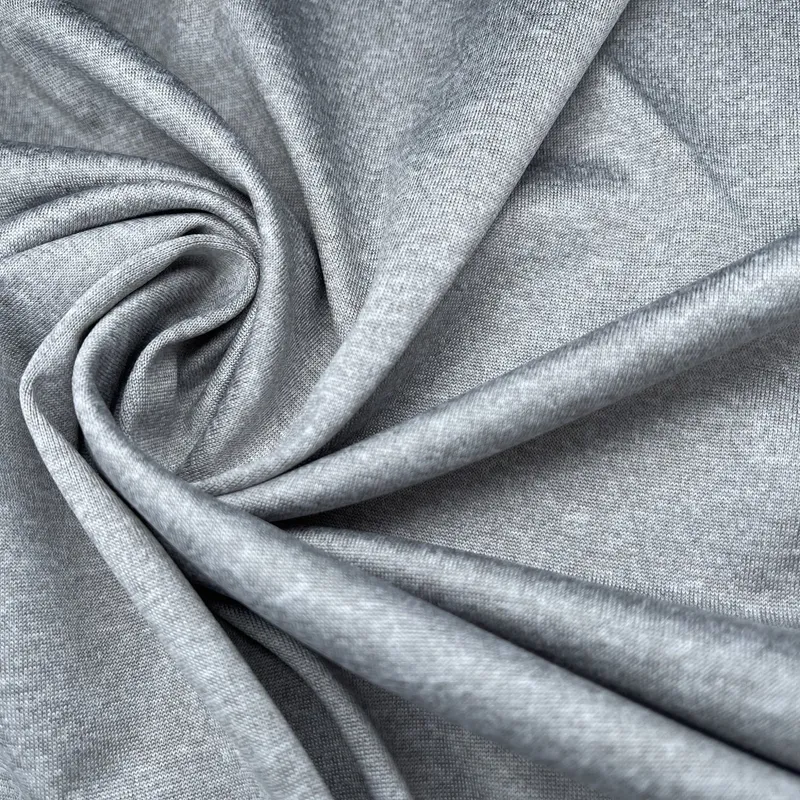 A heather-grey knit gathered into a swirl, its fine grain reading across the frame