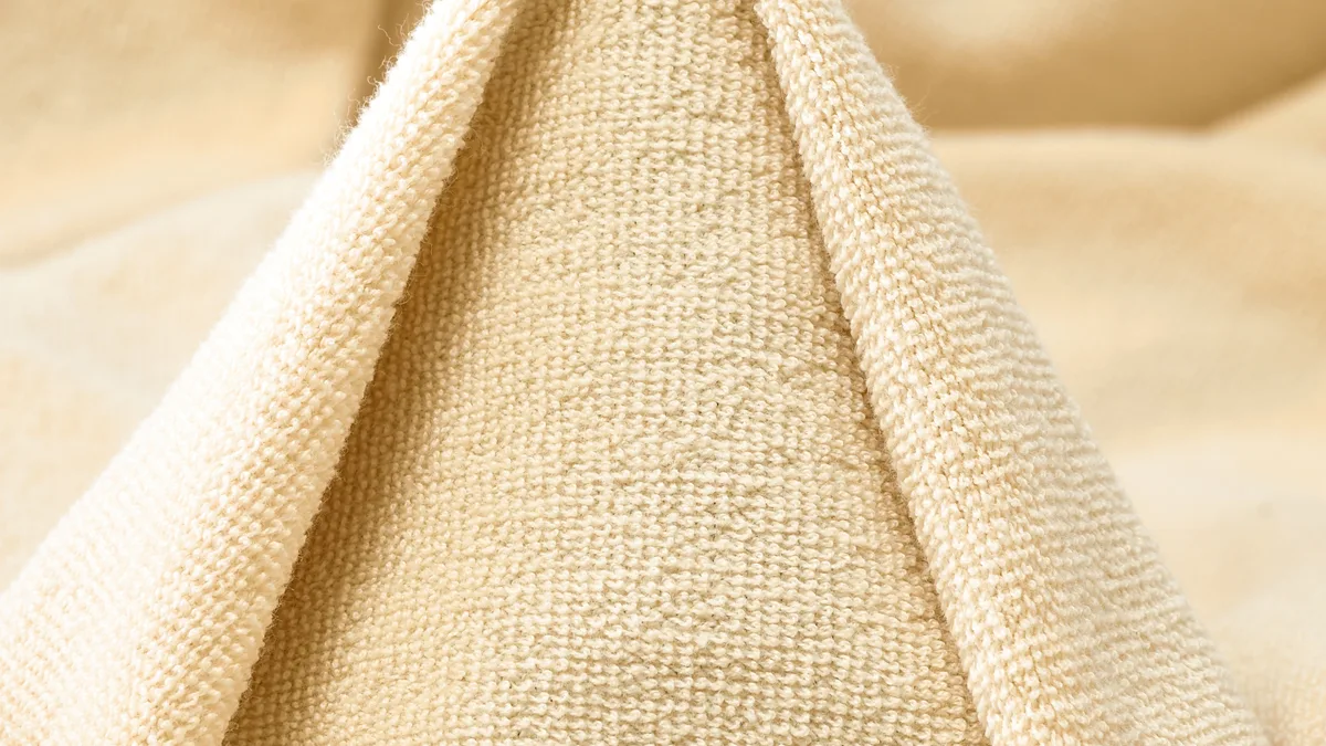 Close-up of cream loop-back French terry, folded to show the soft loops on the reverse