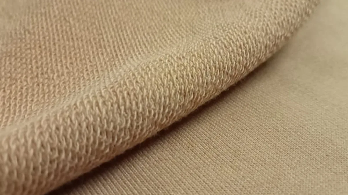 Close-up of beige slub fleece showing its uneven, textured knit grain