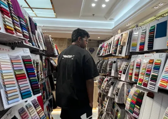 Adebayo Okafor checking fabric swatch books in the showroom