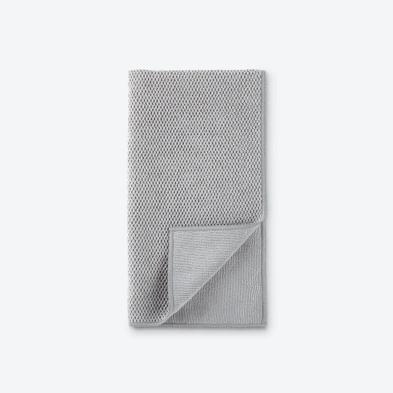 Kitchen towel in grey waffle weave, one corner turned back to show the reverse