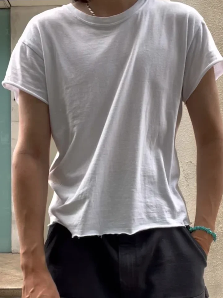 A customer in a plain white boxy t-shirt with a rolled hem