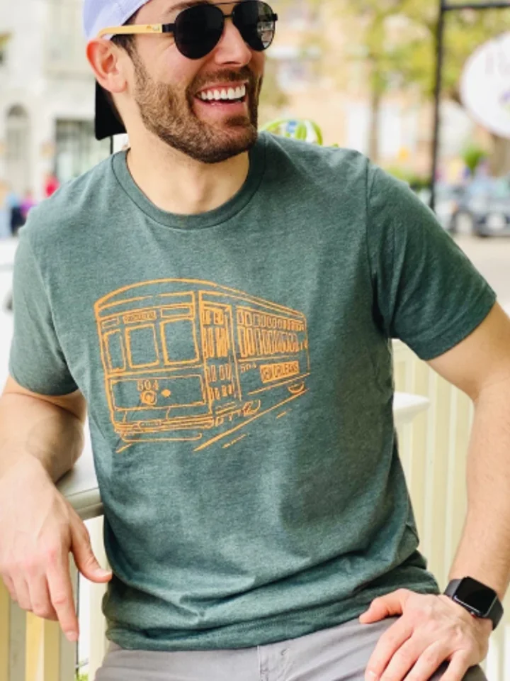 A customer laughing in a green t-shirt with an orange streetcar print