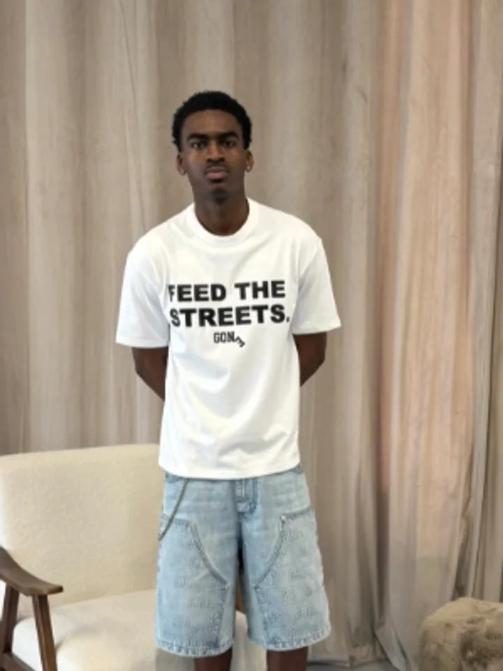 A customer in a printed t-shirt and denim shorts